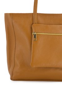 Torba tote w kolorze tan z teksturowanym wykończeniem. Z przodu znajduje się kieszeń na zamek błyskawiczny oraz dwa mocne uchwyty na ramię, co ułatwia noszenie.