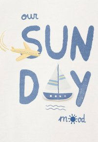 Katoenen shirt met een witte achtergrond met blauwe tekst "SUN DAY," een gele vliegtuig graphic en een blauwe zeilboot met gestreepte details.