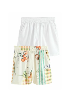 To par elastiske shorts med taljebånd, den ene ens hvid og den anden med flerfarvet print af grøntsager og striber.