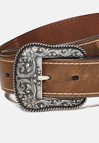 Brown leather belt with a textured surface, featuring an ornate silver-toned metal buckle with floral engravings and white stitching.