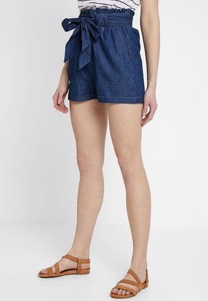 Mörka denimshorts med ett bälte i midjan, med sidofickor och en avslappnad passform. Matchas med bruna sandaler med remmar och en randig skjorta.