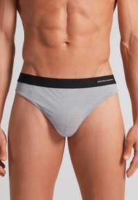 Grå bomuldsboksershorts med en sort elastisk talje, der har hvid branding. Glat tekstur og tætsiddende design for et minimalistisk udseende.