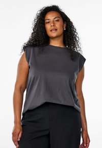 Dark gray sleeveless top with a relaxed fit, made from soft fabric. Features a round neckline and subtle drape at the hem. Paired with black pants.