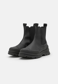Botas Chelsea pretas feitas de borracha com sola espessa, apresentando painéis laterais elásticos e alças para fácil calço. Sola de borracha texturizada.