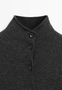 Maglione grigio scuro con colletto alto, caratterizzato da cinque bottoni neri sul davanti e una finitura in tessuto morbido e texture.
