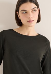 Black long-sleeved top with a wide neckline, made of smooth, lightweight material. The fabric has a subtle sheen and soft texture.