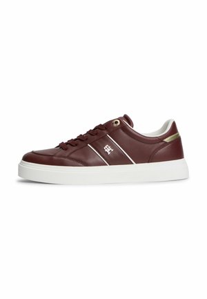 Bordeauxfarvet læder-sneakers med hvid sål, hvide striber, metaløje og lille emblem på siden. Hvid polstret krave med gyldent accent.