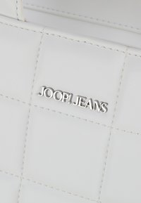 Borsa a tracolla in pelle bianca con texture trapuntata. Presenta un logo "JOOP! JEANS" in argento ben visibile sul fronte.