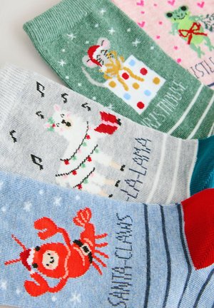 Colorful knitted socks featuring holiday designs: a mouse, llama, frog, and Santa Claws, in green, gray, pink, and blue with patterned accents.