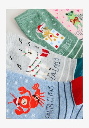 Kleurrijke gebreide sokken met feestelijke ontwerpen: een muis, lama, kikker en de Kerstman, in groen, grijs, roze en blauw met patroonaccenten.