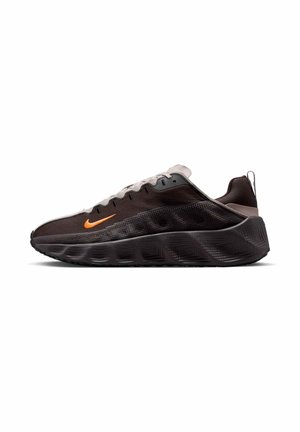 Scarpa Nike nera e grigia con suola spessa e strutturata, logo swoosh arancione, design basso e lacci bianchi vista di lato.