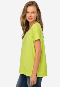 Limoengroen oversized t-shirt gemaakt van zachte stof, met korte mouwen, een ronde halslijn en een comfortabele pasvorm. Geen duidelijke patronen of accenten.