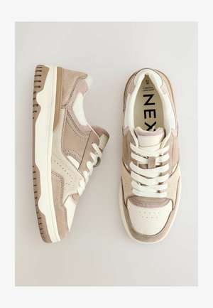 Béžové a krémové tenisky vyrobené z usně a kůže, s perforovanou špičkou, plochými tkaničkami a polstrovaným límcem a jazykem.