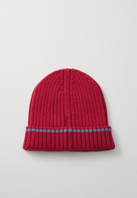 Röd stickad mössa med ribbad textur och vikbar fåll. Har ett blått horisontellt rand runt fållen. Toppen är rundad.