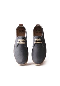 Scarpe in tessuto grigio con punta tonda, design con lacci, laccetti beige, accenti in pelle sul tallone e suola con texture per migliorare la presa. Nome del marchio visibile all'interno.