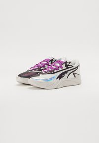 Multifarbede sneakers med et sort-hvidt design, en blank iriserende sidepanel og lilla snørebånd på en struktureret ydersål.