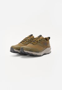 Light brown and olive green outdoor sneakers with mesh upper, rubber outsole, and reinforced toe cap. Features black accents and laces.