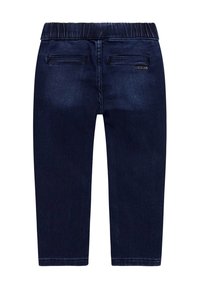 Pantaloni in denim blu scuro con una comoda vita elasticizzata, tasche posteriori e un sottile logo vicino alla vita. Texture liscia, forma affusolata.