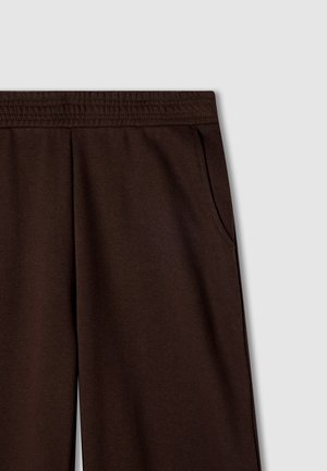 Pantaloni della tuta marroni con vita elasticizzata, tasche laterali e un tessuto morbido e texturizzato. Design semplice, senza motivi o accenti visibili.