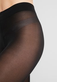 Black sheer tights with a smooth, elastic waistband and slightly glossy texture. Thin, lightweight fabric with a uniform finish.