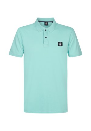 Polo de algodón en un tono verde azulado claro, con cuello, tres botones y un parche cuadrado negro en el lado izquierdo del pecho. Mangas cortas, corte relajado.