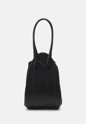 Sac à main en cuir noir avec des anses allongées et des détails de couture géométrique sur le devant, posé debout sur un fond blanc.