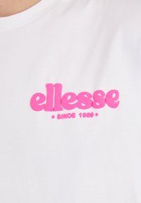 Hvitt bomulls t-skjorte med en hevet rosa logo som sier "ellesse" med "SINCE 1966" under, glatt tekstur, og klassisk rund hals design.