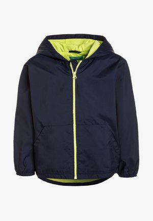 Veste coupe-vent marine avec doublure de capuche verte, fermeture éclair sur le devant, poignets élastiques et deux poches latérales. Tissu léger et lisse.