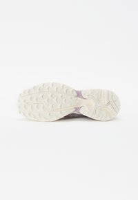 Leichter Laufschuh mit einer strukturierten weißen Gummisohle, die ein pink-lila Farbverlaufdesign auf der Mittelsohle aufweist.