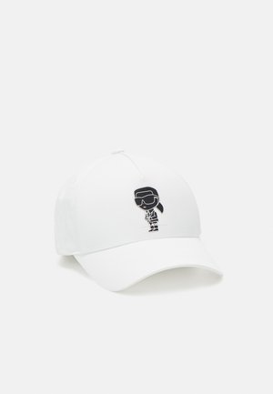 Biała czapka bejsbolowa z małą czarną postacią z kreskówki w okularach przeciwsłonecznych i garniturze na środku przodu.