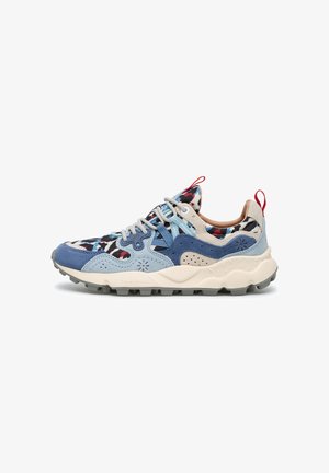 Trail running shoe with blue suede overlays, patterned fabric upper, thick white sole with traction, and red pull tabs at heel and tongue.