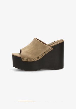 Mule beige de ante con punta abierta, tachuelas de bronce en la parte superior y tacón cuña grueso negro.