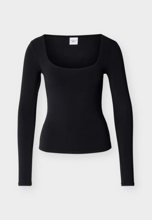 Top nero a maniche lunghe aderente con scollo quadrato e una piccola etichetta bianca all'interno del colletto, mostrato su uno sfondo bianco.