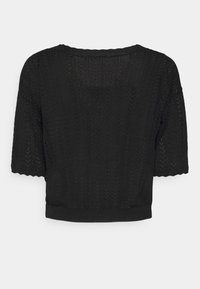 Svart stickad topp med korta ärmar, med ett zickzack-mönster, rund halsringning och en något kortad nederkant. Strukturdesign och lättviktig.