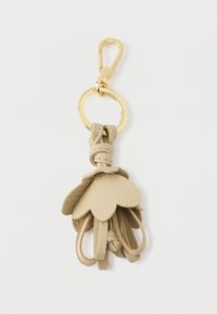 Portachiavi in pelle beige, caratterizzato da forme di foglia sovrapposte e un gancio metallico dorato. Materiale testurizzato con una finitura liscia.