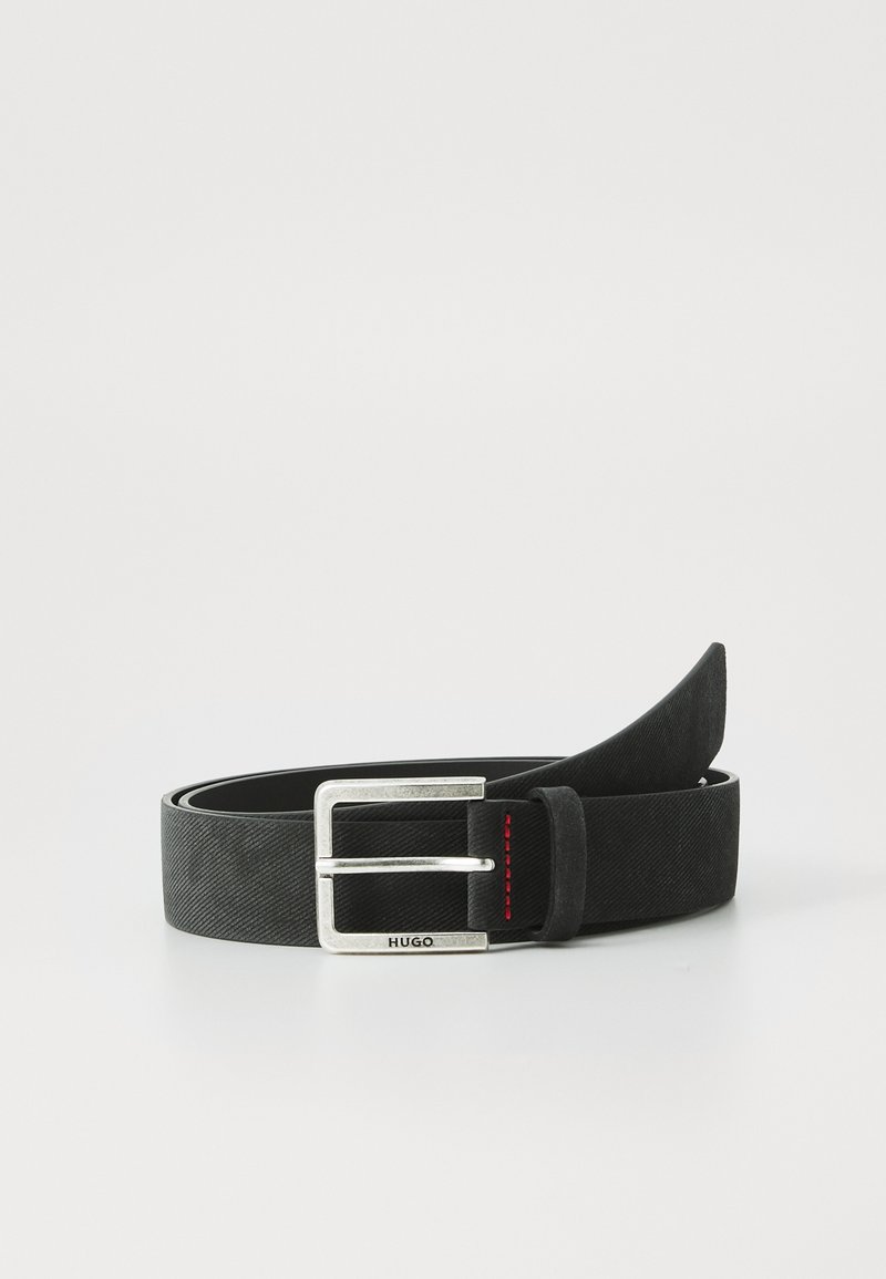 Mustan kankaisen vyön, jossa on suorakulmainen hope buckle, jota korostaa punainen ommel. Vyöllä on sileä pinta ja minimalistinen muotoilu.