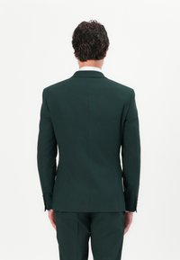 Dark green suit jacket with a slim fit, featuring a notch lapel, two button closure, and subtle texture visible in the fabric.