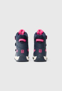 Stivali per bambini blu navy e rosa con alta tomaia, con linguette posteriori e suola bianca, mostrati da dietro su uno sfondo semplice.