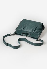 Borsa a tracolla in pelle teal con design a ribalta, tracolla regolabile e dettagli metallici. Presenta una superficie liscia e texture.