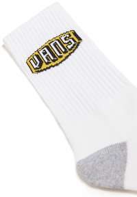 Calcetín blanco con textura acanalada que presenta un logo de Vans en negro y amarillo, con un acento gris en el talón. Material suave, longitud estándar de caña.
