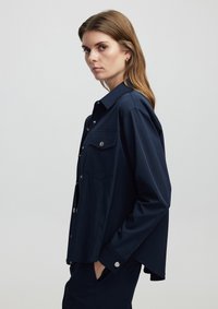Donkerblauwe button-up shirt van gladde stof, met een kraag, twee borstzakken en zilveren drukknoopaccenten.