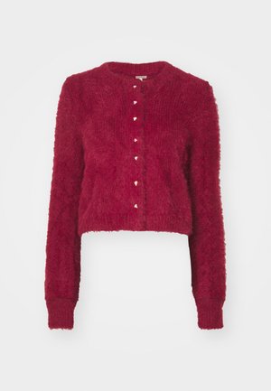 Crvena skraćena vestica od mekanog materijala, s dugim rukavima, okruglim izrezom i ukrasnim dugmadi u obliku srca duž prednje strane.