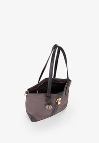 Grijze stoffen tote bag met zwarte leren accenten, gouden hardware en dubbele schouderbanden; heeft een open bovenkant en een binnenzak.