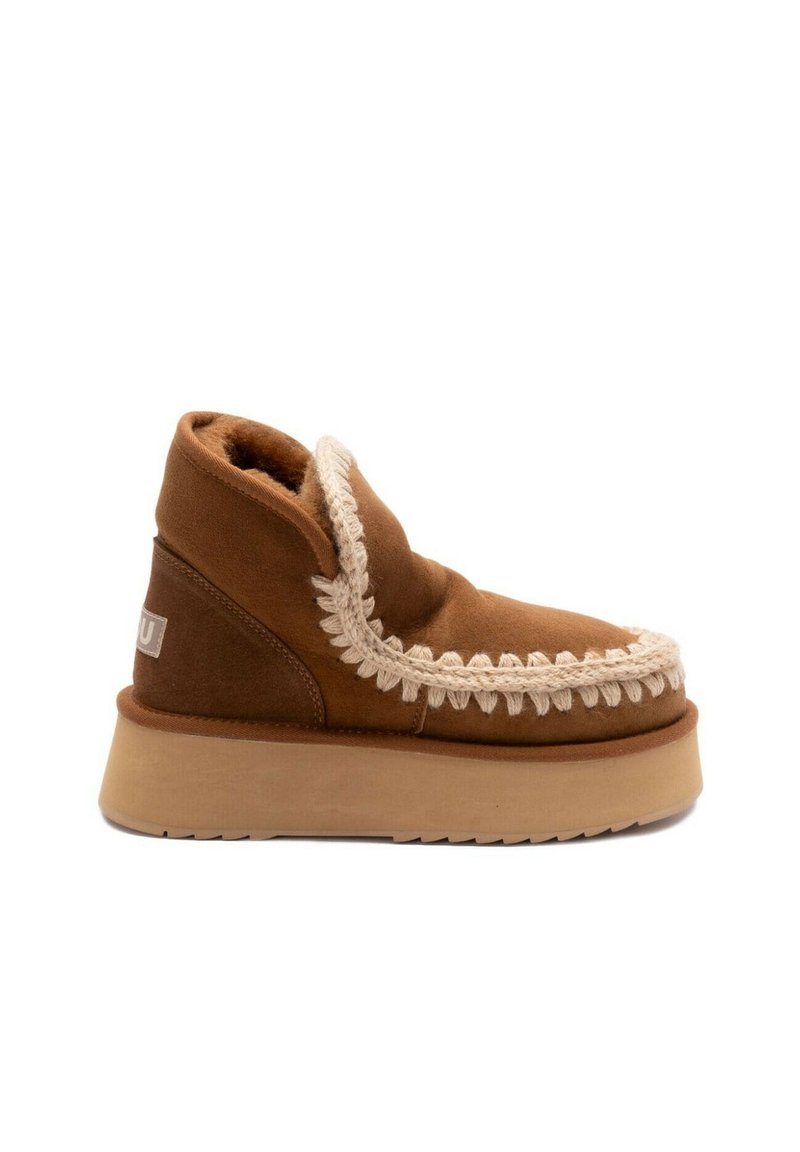 Stivale in suede marrone con un interno morbido, cuciture decorative bianche e una suola spessa beige. Presenta una forma arrotondata e un design con caviglia alta.