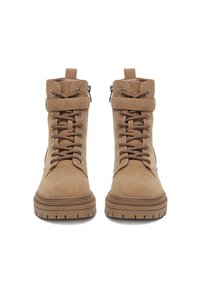 Karmelowe zamszowe botki za kostkę z wiązanym zapięciem, metalowymi akcentami, bocznymi zamkami błyskawicznymi oraz masywną gumową podeszwą z teksturowanym bieżnikiem.