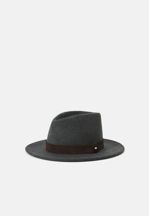 Harmaa tuntuva fedora-hattu, jossa on ruskea mokkanahkavyö ja pieni hopea koru. Pyöreä kruunu ja leveä, tasainen lippa.