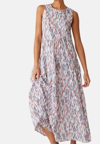 Robe maxi avec design à volants, sans manches, présentant un motif ikat coloré dans des nuances de blanc, rose, bleu marine et orange. Matière légère.