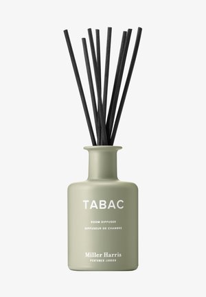 Mattgrüne Miller Harris Tabac Raumduftflasche mit sieben schwarzen Schilfrohrstäbchen, die aufrecht stehen.