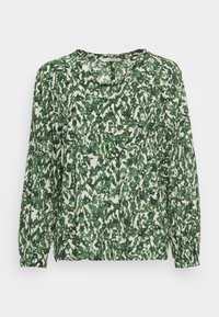 Blouse à manches longues avec un motif floral en feuilles vertes et blanches, poignets élastiques et un col rond avec une petite fente en V.