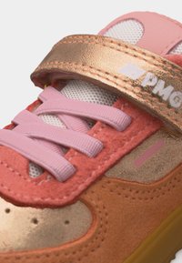 Παιδικό αθλητικό παπούτσι με ροζ κορδόνια, πορτοκαλί και χρυσές σουέντ επιφάνειες, λευκή γλώσσα από δίχτυ, και χρυσό λουράκι με βέλκρο με την ονομασία της μάρκας.